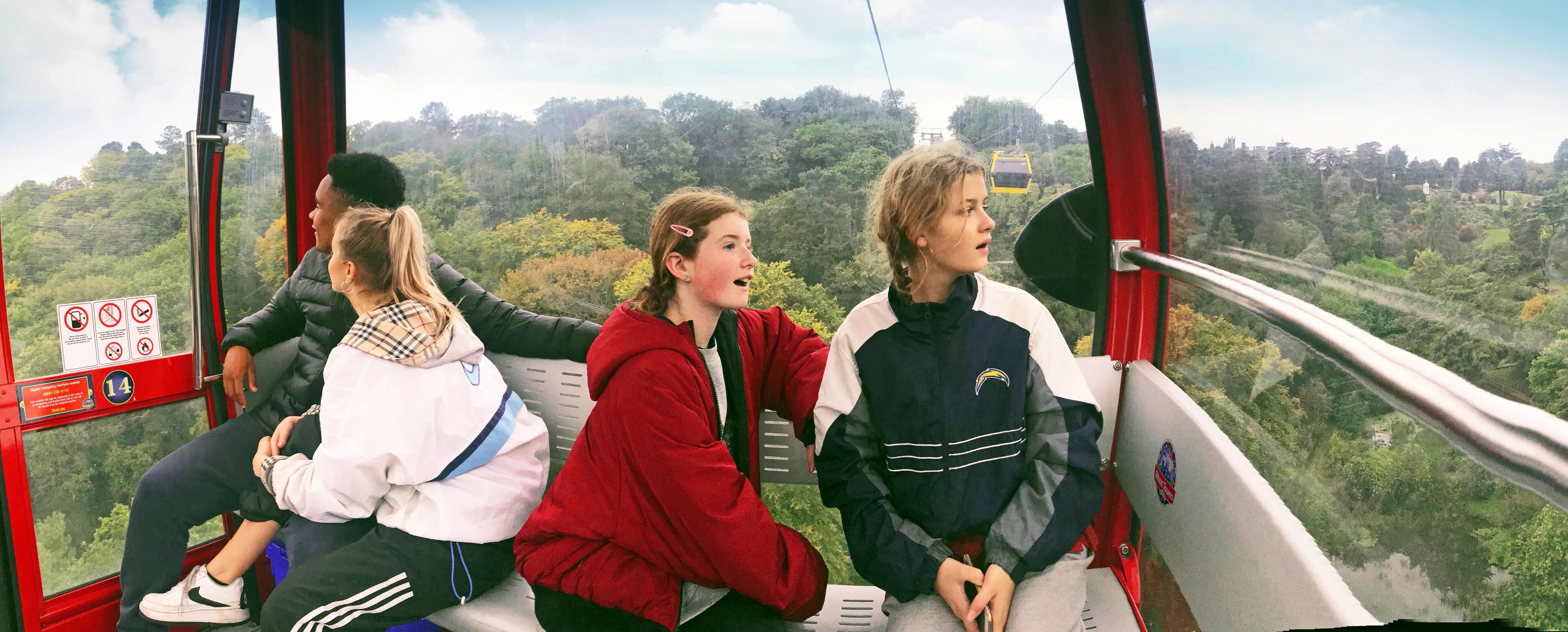 Group of people inside a Skyride gondola surrounded by an aerial view of Alton Towers Resort